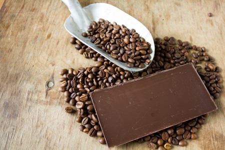 Coffee beans and shovel on wooden background