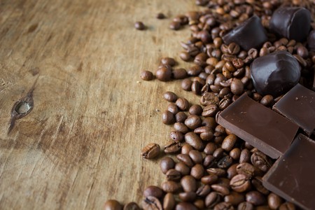 Tiles of dark  delicious candy coffee beans on a wooden backgroundの写真素材