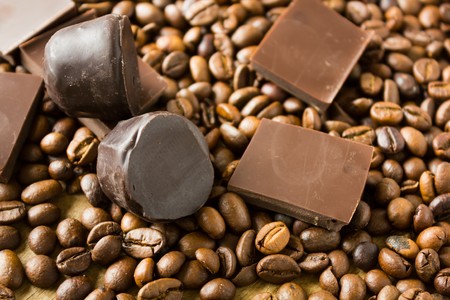 Tiles of dark  delicious candy coffee beans on a wooden backgroundの写真素材