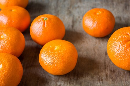 Delicious fresh tangerines lie on a wooden tableの写真素材