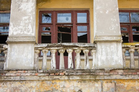 Old vintage abandoned building with broken windows and a collapsed balconyの写真素材