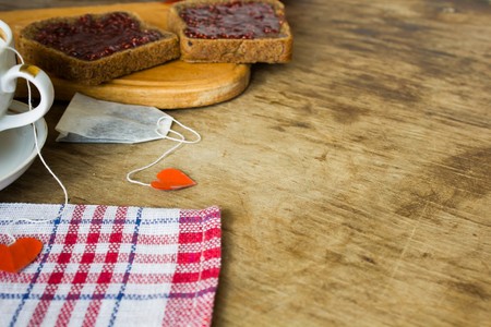 Vintage large cup with black tea and raspberry jam in a plateの写真素材