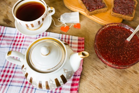 light breakfast or lunch , Raspberry jam slices of black bread Vintage cup of tea and teapotの写真素材