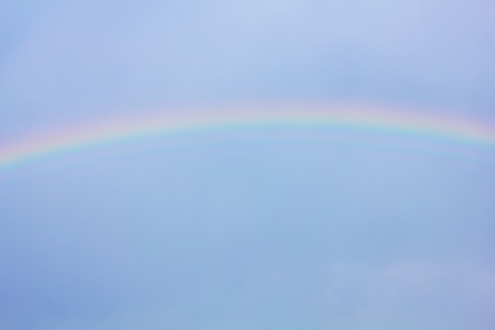 beautiful classic rainbow across in the blue sky after the rainの写真素材