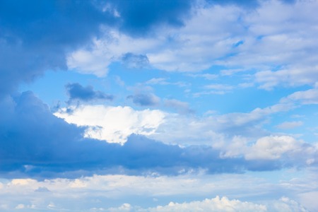 blue sky with white clouds of different shapes in perspectiveの写真素材