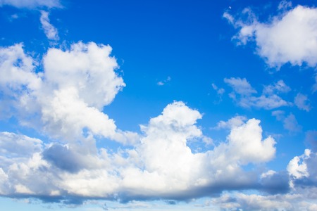 blue sky with white clouds of different shapes in perspectiveの写真素材