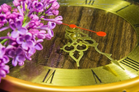 Old golden vintage clock with arrows and original colors lying nextの写真素材