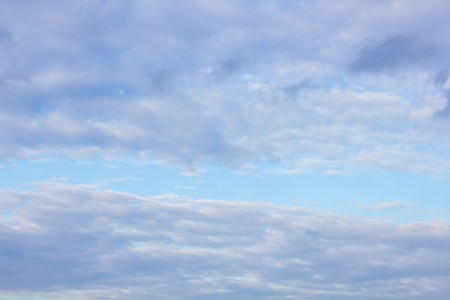 blue sky with white clouds of different shapes in perspective