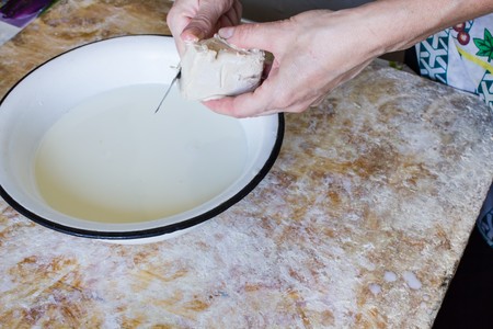 preparation of bechamel sauce in a pan and flour, milk on the tableの写真素材