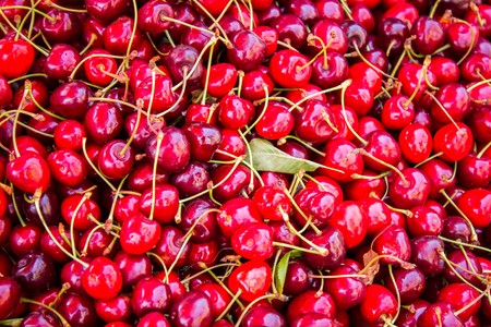 Ripe cherries on a large market close up view as backgroundの写真素材