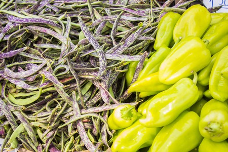 Lots of ripe beans and sweet pepper on the counter of the vegetable market