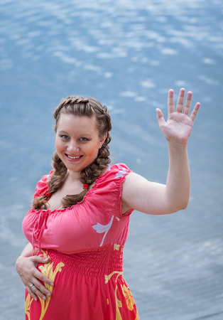 Pregnant woman waving hand. Concept of motherhood and femininityの写真素材