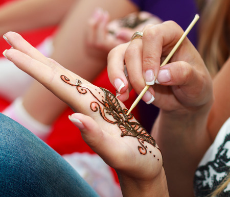 Caucasian woman applying henna tattooの写真素材