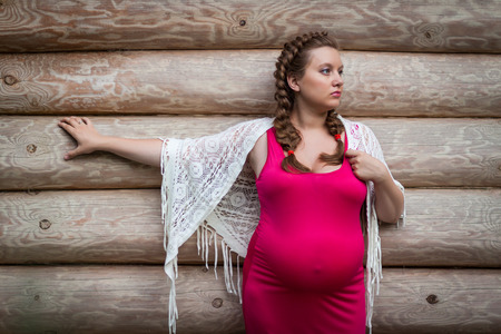 Pregnant woman outdoors, log backgroundの写真素材