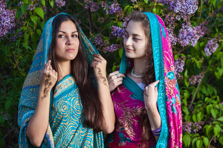 Asian women dressed in traditional saris with mehndi in lilacの写真素材