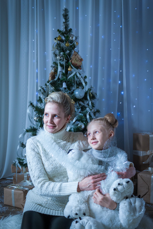 Beautiful woman and her daughter near the New Year treeの写真素材