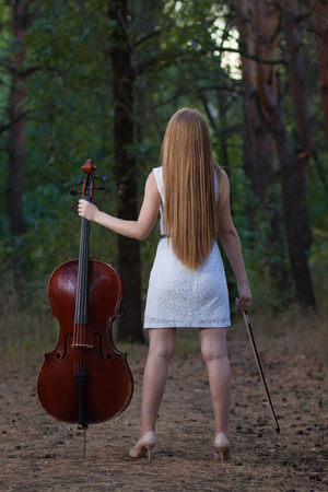 Woman cello player with instrument outdoorsの写真素材