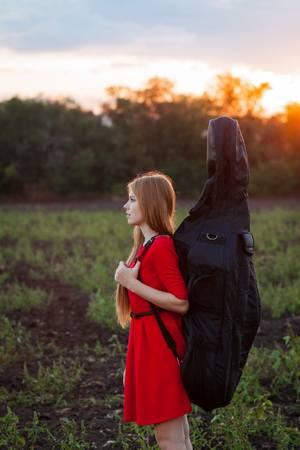 Woman musician travelling with cello outdoorsの写真素材