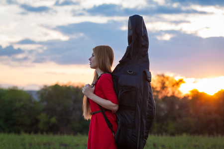 Woman violoncellist with cello at natureの写真素材
