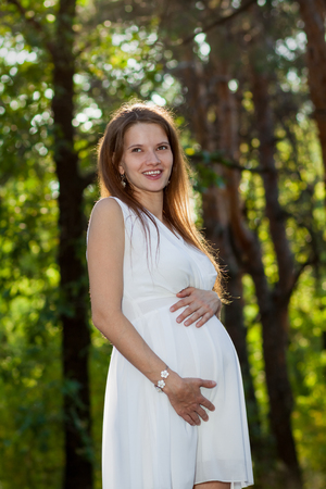 Pregnant woman smiling in the forest aloneの写真素材