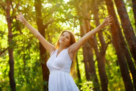 Happy pregnant woman breathing fresh air in the woodlandの写真素材