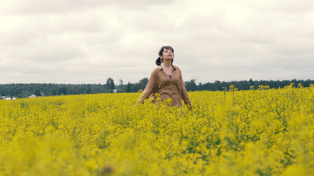Happy young woman on a summer walk. Woman walking in summer fieldの写真素材