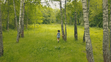 Arial view smiling young woman in forest. Follow me into forestの写真素材