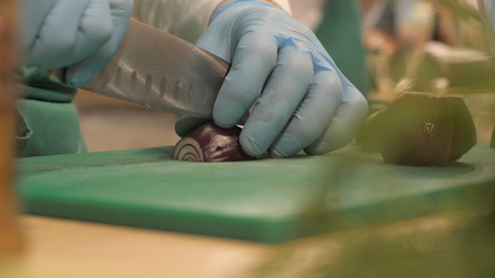 Hands chef cook cutting red onions on board in restaurant kitchen close upの写真素材