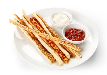 Restaurant food - grissini bread sticks with red and white sauces isolated at the white backgroundの写真素材