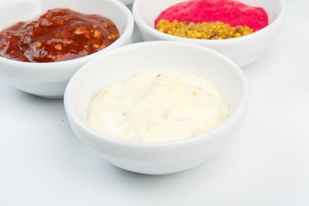 Closeup of mayonnaise and other sauces in white bowlsの写真素材