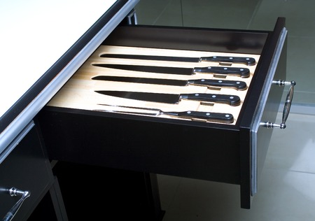 Knife set in an opened drawer of modern kitchen