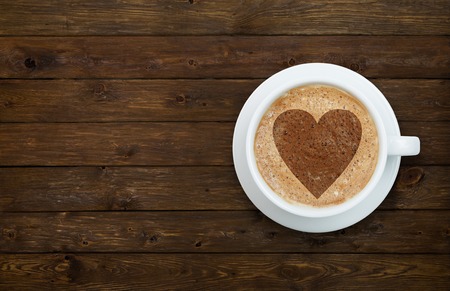 Cup of latte coffee with heart on the wooden tableの写真素材