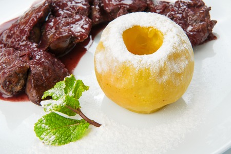 Restaurant food - chicken liver in pomegranate sauce with baked apple close-upの写真素材