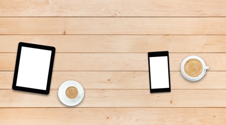 Two gadgets - smartphone and tablet PC with coffee on a wooden table, couple concept