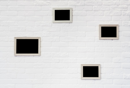 Empty black wooden beige picture frames at white brick wallの写真素材