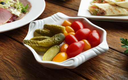 Restaurant appetizer food. Restaurant food assortment plate. Pickled vegetables, tomato, cucumber platter at restaurant. Catering, served table. Pickled vegetables food plate.の写真素材