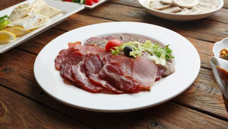 Restaurant food and catering. Restaurant food, meat assortment plate. Ham, bacon, smoked meat at restaurant banquet table appetizer.の写真素材