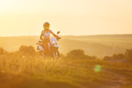 Woman biker rides in fields.の写真素材