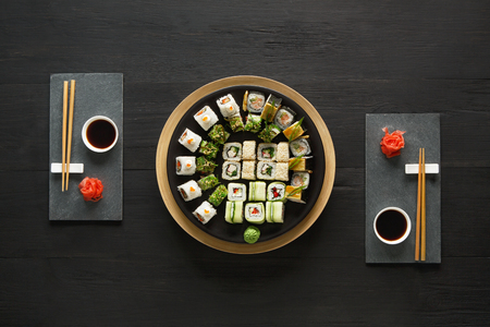 Japanese food restaurant, sushi maki gunkan roll plate or platter set. Set for two with chopsticks, ginger, soy, wasabi.の写真素材