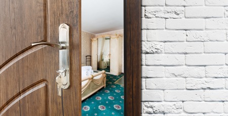 Half opened door to a bedroom. Door handle, door lock. Lounge door half open. Opening door. Welcome, privacy concept.の写真素材