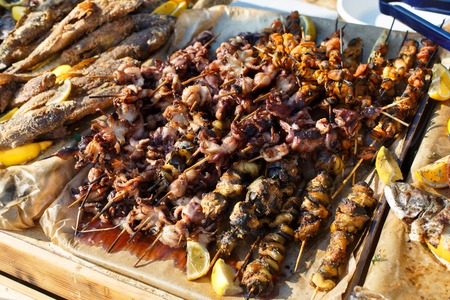 Plenty of seafood, fish, octopus, mussels grilled at barbecue. Seafood bbq outdoors at picnic,...
