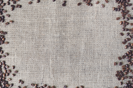Burlap texture with coffee beans border. Sack cloth burlap texture background. Brown natural sackcloth canvas background with frame and copy space. Coffee border at hessian textile, soft color toningの写真素材