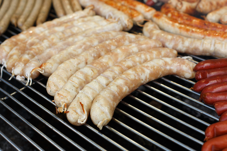 Sausage party. Barbecue large grill outdoors. Cookout bbq food. Big roasted pork german bratwurst, white polish kielbasa. Meat meal. Street food, fast food. Tasty snackの写真素材