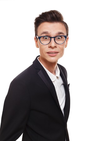 Surprised man in eye glasses isolated at white. Portrait of amazed guy looking goggle-eyed at camera. Businessman in black suitの写真素材