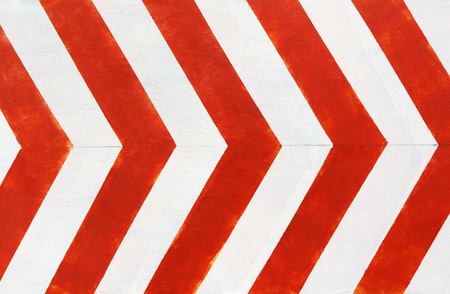 Red and white stripes closeup background. Painted concrete wall, looking like road bend traffic sign. Contrast bright lines surface.の写真素材