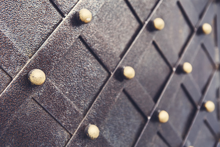 Vintage metallic pattern of medieval gate. Decorative grunge checkered iron structure background. Architectural detail, selective focusの写真素材