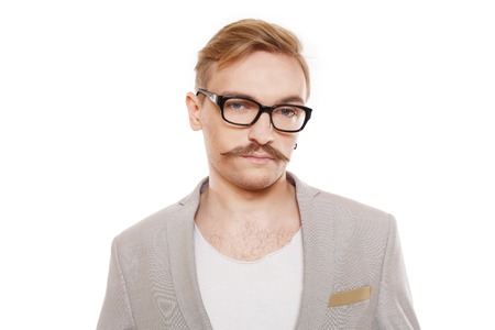 Young stylish blond man in beige blazer isolated at white. Portrait of confident guy looking at camera. Boy style, trendy male person in eyeglasses and black suit. Modern businessman.の写真素材
