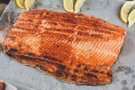 Salmon red fish juicy roasted fillet grilled on barbecue. Healthy seafood bbq outdoors at picnic, party.の写真素材