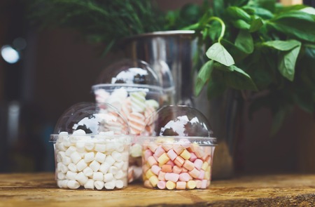 Desserts choice. Marshmallow chewing candies in glass jars on counter bar for sale. Traditional american sweets for sale, closeupの写真素材