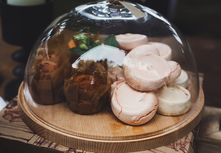 Desserts choice. Chocolate muffins, cookies and biscuitss in glass jar on counter bar for sale. Meringue sweets and baked cakes stacks.の写真素材
